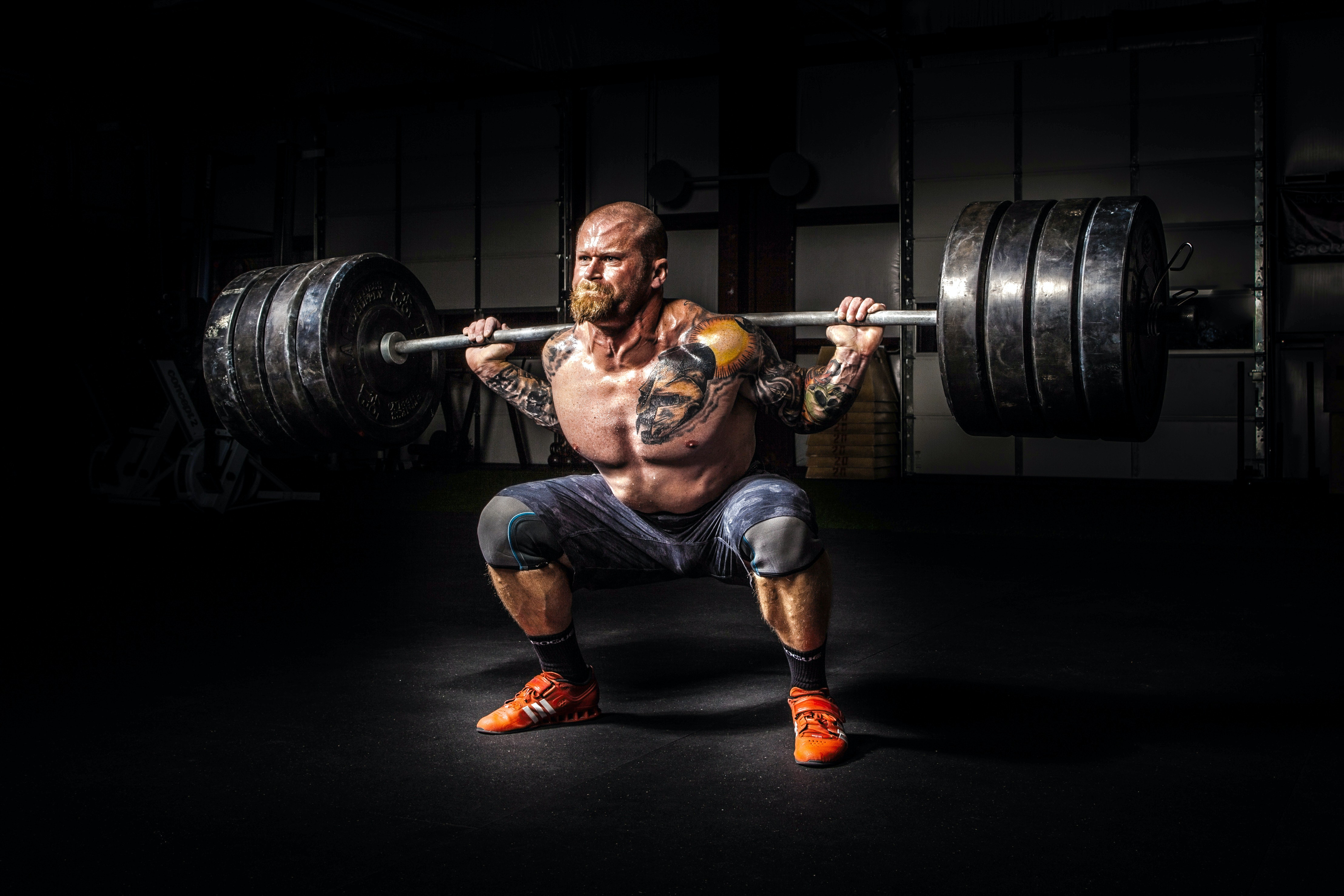 Tattooed man power lifting bar bell