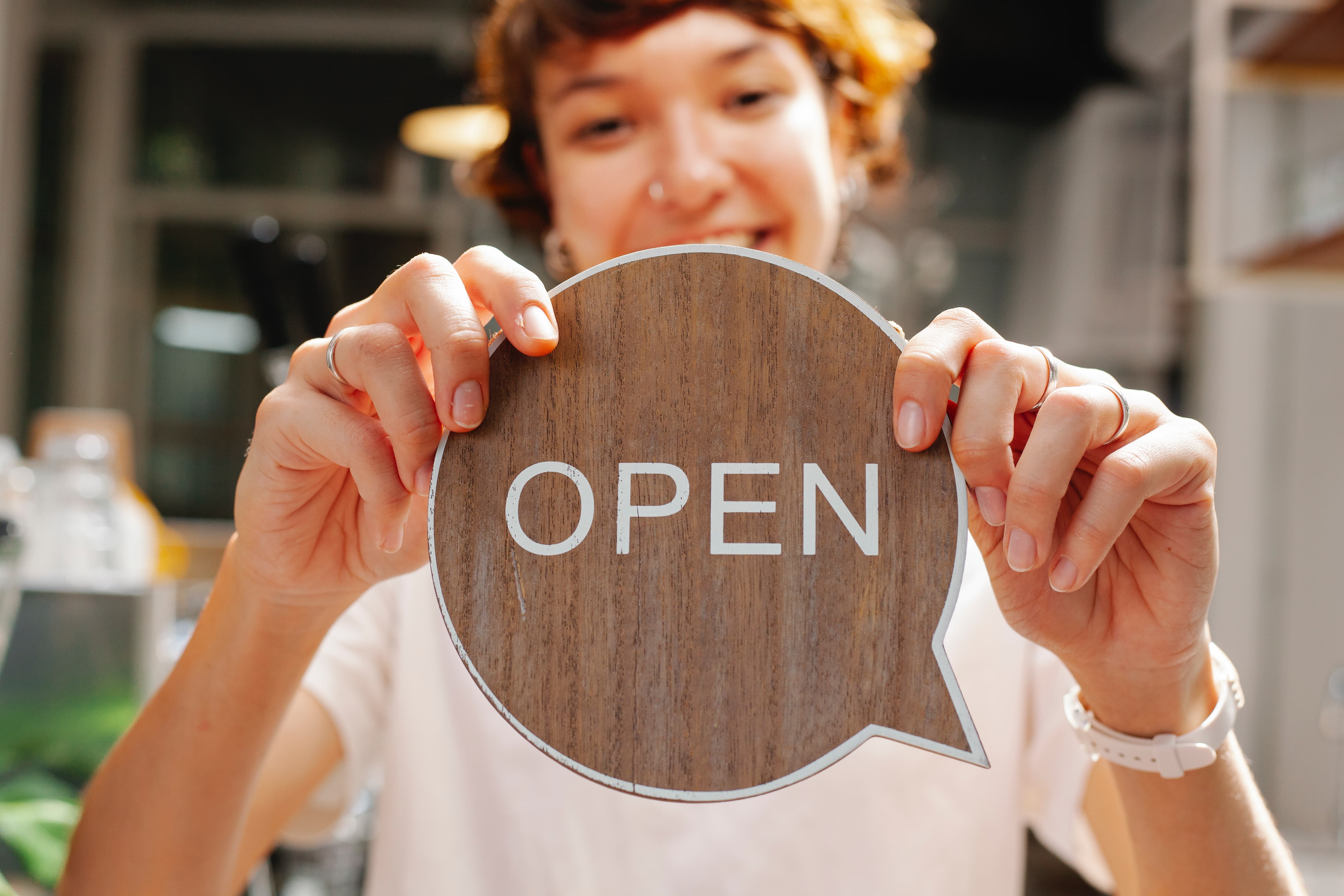 Girl holding open sign